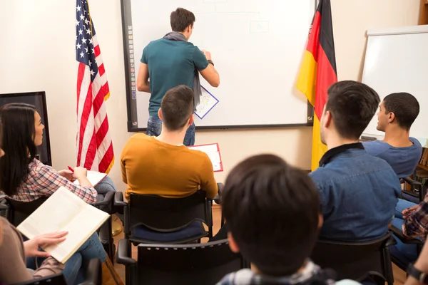 Dozent erledigt Aufgabe an der Tafel — Stockfoto