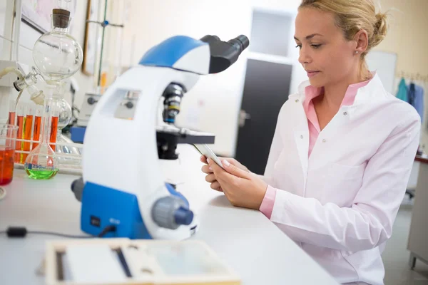 Il lavoratore del laboratorio cerca dati chimici su ipod — Foto Stock