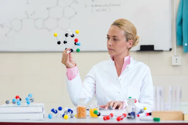 Jovem químico no gabinete olhar em modelo molecular — Fotografia de Stock