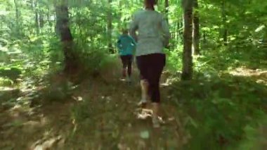 ormanda koşu çalıştırıyor. Eğitim, çalıştırma, jogging, fitness, runner - 4 k video kadın