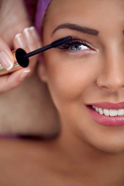 Beautiful woman with long false eyelashes applying mascara — Stock Photo, Image