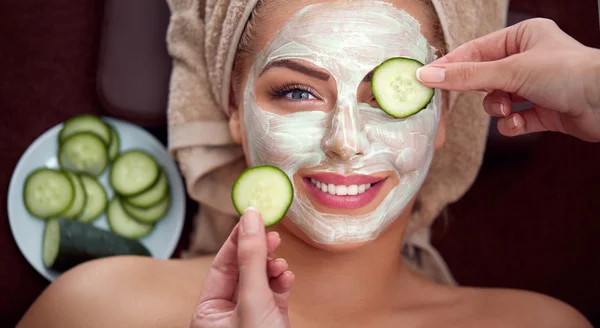 Joven chica sonriente con máscara cosmética en el salón de spa — Foto de Stock