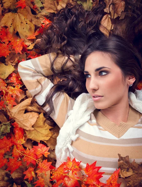 Autumn woman lying in orange leaves — Stock Photo, Image