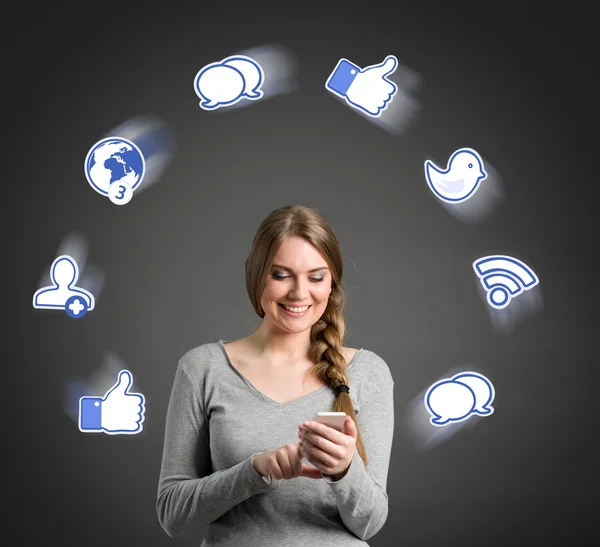 Mujer joven sonriente usando un teléfono inteligente —  Fotos de Stock