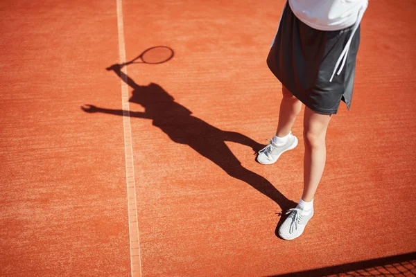 Piernas y sombra del tenista en pista de tenis — Foto de Stock