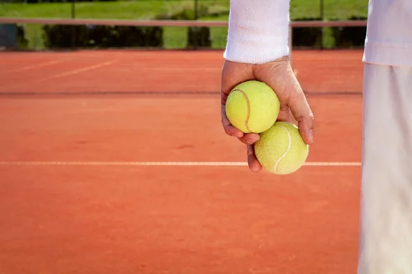 Close up of tennis balls in sportsman hand — Stock Photo, Image