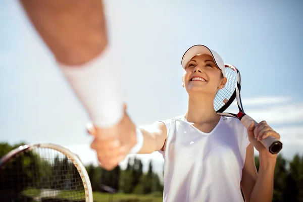 Young female tennis player greets with traine — Stock Photo, Image