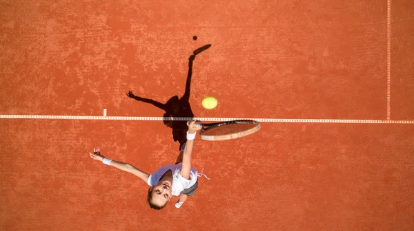 Jugador de tenis golpeando pelota en terreno de tenis — Foto de Stock