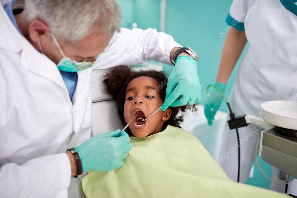Dentist repairing kid's tooth
