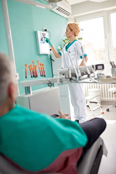 Женщина-стоматолог осматривает стоматологический рентген — стоковое фото