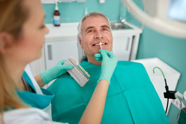 Homme en fauteuil dentaire avec une dentiste féminine — Photo