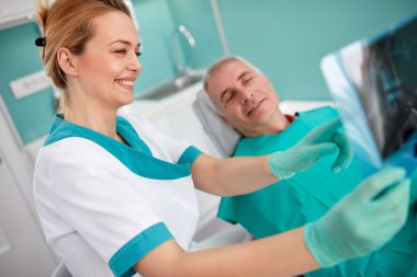 Kadın diş hekimi diş X-ra üzerinde diş ile ilgili sorun göster