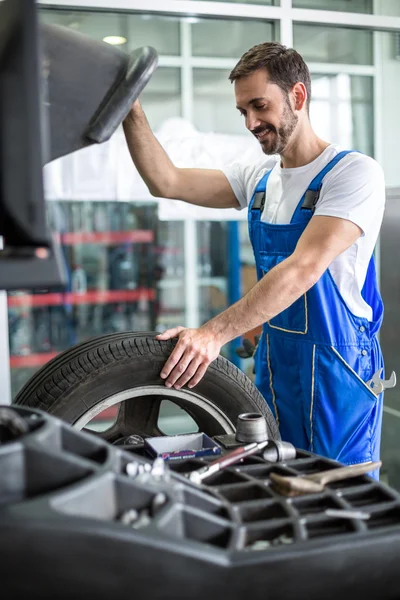 Mecánico reparador de instalar la rueda del coche en el neumático — Foto de Stock