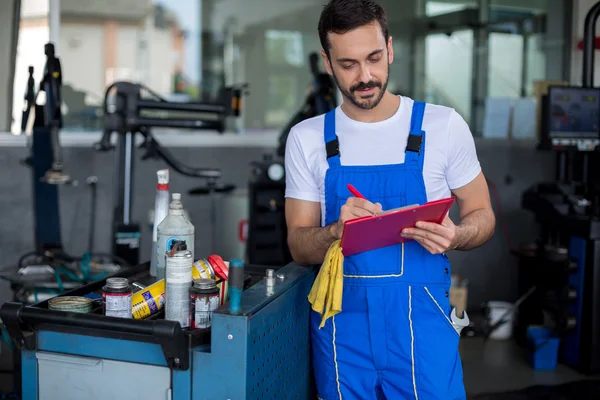 Konzentriertes mechanisches Schreiben auf Klemmbrett — Stockfoto