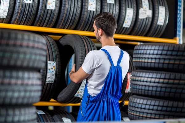 Venda mecânica um pneu novo para carro — Fotografia de Stock