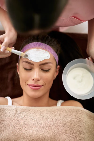 Lächelnde Frau bei der kosmetischen Behandlung ihrer Gesichtshaut — Stockfoto