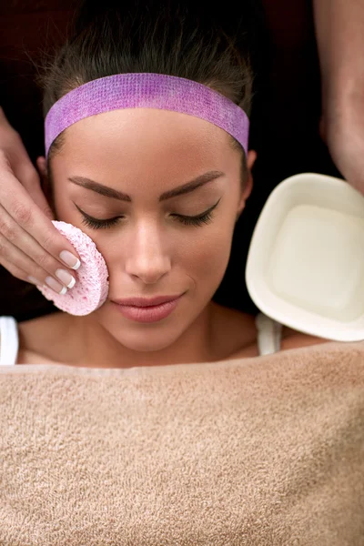 Kosmetikerin putzt Gesicht einer jungen Frau — Stockfoto