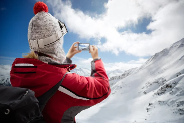 Frau am Berg macht Foto mit Smartphone — Stockfoto