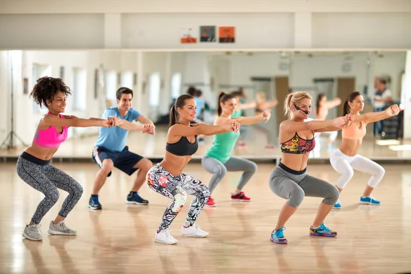 Female trainer with young people doing exercises — Stock Photo, Image