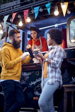 Fast food önünde flört eden çok ırklı bir çiftin dikey görüntüsü 