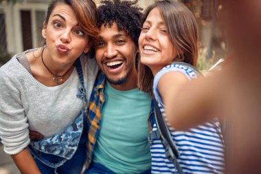 Arkadaşlar güzel bir havada barın arka bahçesinde komik bir selfie çekiyorlar. Kaliteli arkadaşlık zamanı.