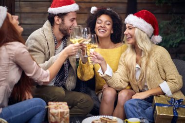 Bir grup neşeli genç Noel 'i ya da yeni yıl partisini kutluyor ve şenlikli atmosferde şampanya içiyorlar. Xmas, arkadaşlar, tost, eğlence, parti konsepti
