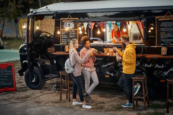 Grupo Jóvenes Socializando Mientras Comen Aire Libre Frente Camión Modificado — Foto de Stock