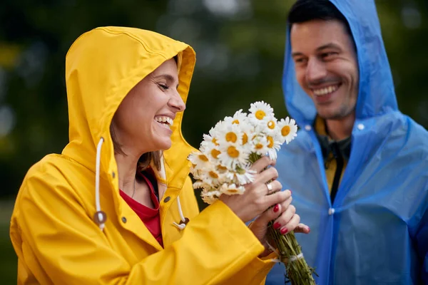 女人从男人那里收到一束鲜花的画像 雨天的爱情 — 图库照片