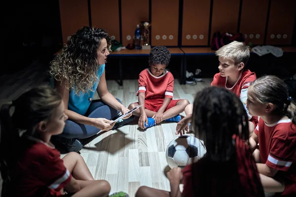 Egy Női Edző Kis Játékosai Öltözőben Megbeszélik Meccs Stratégiáját Gyerekcsapat — Stock Fotó