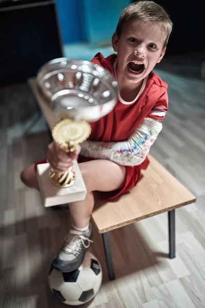 Emocionado Pequeño Jugador Vestuario Posando Con Trofeo Ganado Partido Deportes — Foto de Stock