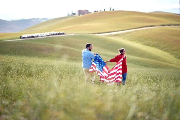 Ett Par Förälskade Promenader Ett Fält Med Den Amerikanska Flaggan — Stockfoto