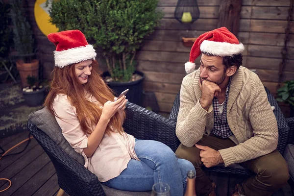 新年のパーティーで携帯電話の女性のメールを見て退屈白人男性 失礼な行動概念 — ストック写真