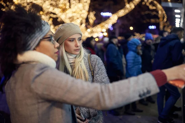 İki bayan arkadaş bir kış günü şehirde yürüyüş yapıyorlar.