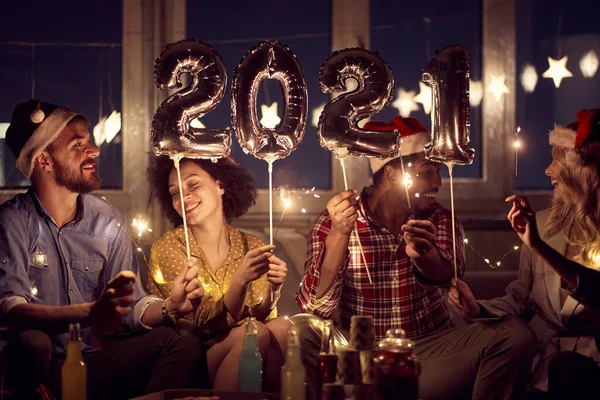 Cheerful couples having good time together at New Year eve home party in festive atmosphere. New Year, home party, friends time together