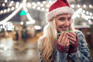 Karlı bir kış gecesinde dışarıda çay içen bir kadının portresi.