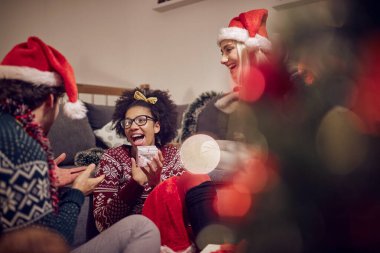 Genç bir kız, yeni yıl partisinde neşeli bir ortamda arkadaşından aldığı hediye için heyecanlı. Xmas, yeni yıl, arkadaşlar, kutlama