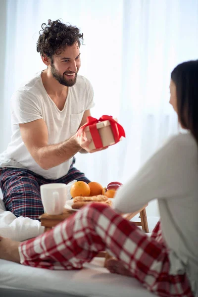 彼氏驚くべきガールフレンドとクリスマスの朝の贈り物 — ストック写真