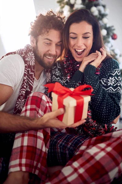 家庭でクリスマスの朝に贈り物を共有するカップルを愛する — ストック写真