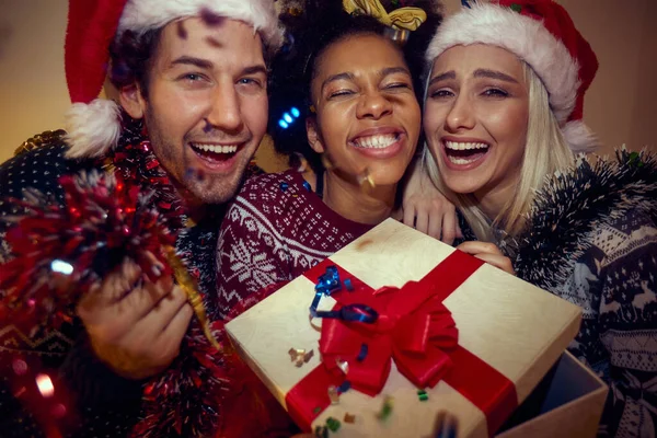 Przyjaciele Śmieją Się Świętując Boże Narodzenie Patrząc Kamerę Kontakt Wzrokowy — Zdjęcie stockowe