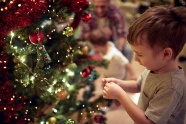 Mutlu bir ailenin Noel ağacını evdeki tatil atmosferinde süslemesi. Birlikte, yeni yıl, aile, kutlama