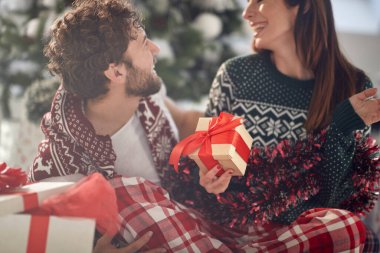 Genç bir çift güzel bir tatil sabahında evde Noel hediyelerini paylaşırken romantik anlar yaşar. Noel, ilişki, aşk, birlikte