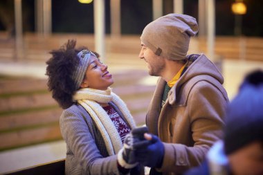 Güzel bir gecede buz pateni pistinde dans eden genç bir çift. Kayak, yakınlık, aşk, birlikte