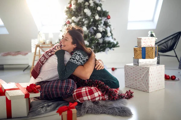 Een Vrolijk Stel Zit Grond Een Knuffel Omringd Door Kerstcadeautjes — Stockfoto