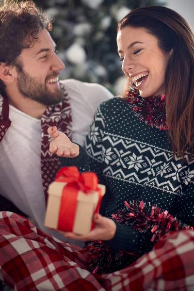 素敵な休日の朝に自宅でクリスマスプレゼントを与える一緒に素晴らしい時間を過ごす愛の若いカップル クリスマス 一緒に — ストック写真