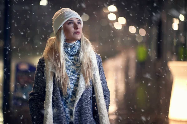 在一个大雪的冬夜里走在外面的一个女人的近照 — 图库照片