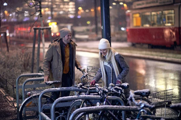 Gülümseyen Kafkasyalı çift, kışın sokakta bisiklet sürüyorlar.