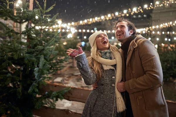 Şehirde büyülü bir gecede birbirine aşık genç bir çift kar yağışı için heyecanlı. Noel ağacı, aşk, ilişki, Xmas, kar