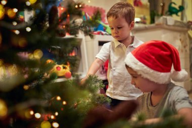 Noel ağacını Noel atmosferinde süsleyen çocuklar. Birlikte, yeni yıl, aile, kutlama