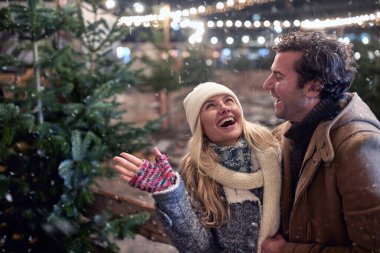 Kız arkadaş ve erkek arkadaş bir kış gecesinde birlikte bir Noel ağacı seçiyorlar.