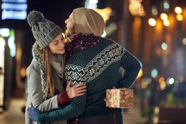 A boyfriend hides Xmas present for his girlfriend while walking the city together on a beautiful holiday night. Christmas, relationship, love